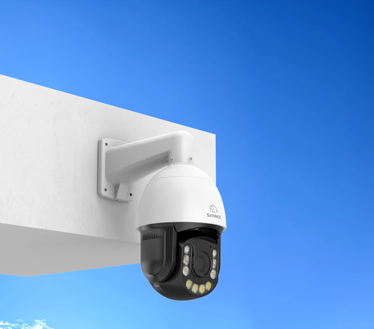 Security camera mounted on a wall with a clear blue sky background